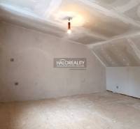 Unfertiger Dachbodenraum in einem Einfamilienhaus, helle Wände und Holzboden.