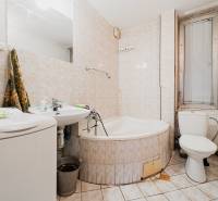 Badezimmer mit Badewanne, Waschbecken und Waschmaschine in einem Einfamilienhaus.