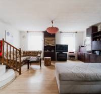 Wohnzimmer in einem Einfamilienhaus mit Holzboden und bequemen Sitzgelegenheiten.