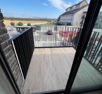 Balkon mit Holzboden in einer 2-Zimmer-Wohnung mit Blick auf die Umgebung.