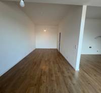 Ein Zimmer mit Holzboden in einer 2-Zimmer-Wohnung, neutrale Wände.