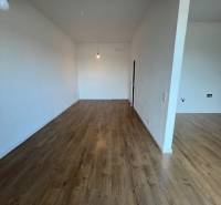 2-Zimmer-Wohnung mit Holzboden und weißen Wänden.