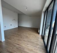 Geräumiges Wohnzimmer in einer 2-Zimmer-Wohnung mit Balkon, Boden mit Holzdekor.