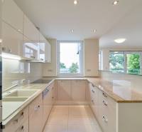 Küche in einer 3-Zimmer-Wohnung mit großem Fenster, weißen Schränken und glänzender Arbeitsplatte.