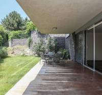 Terrasse mit Holzboden, Gartenmöbeln und Grünflächen bei einer 3-Zimmer-Wohnung.