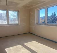 Das Innere eines Einfamilienhauses mit hellem Boden und großen Fenstern für ausreichend Licht.