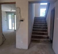 Stahltreppen und rohe Wände in einem Einfamilienhaus mit geplantem Interieur.