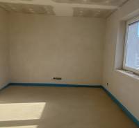 Ein leerer Raum in einem Einfamilienhaus mit einem Fenster und unvollendeten Wänden.