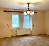 Ein Zimmer in einer 2-Zimmer-Wohnung mit einem Holzboden und einem hängenden Kronleuchter.