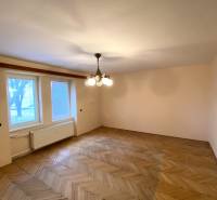 Ein Zimmer in einer 2-Zimmer-Wohnung mit einem Boden in Holzoptik und einem zentralen Kronleuchter.