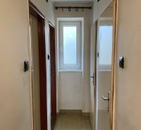 Ein enger Flur in einer 2-Zimmer-Wohnung mit hellem Bodenbelag.