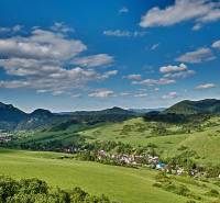Schöne Landschaft in der Umgebung von Lechnice mit landwirtschaftlichen und forstwirtschaftlichen Flächen unter blauem Himmel.