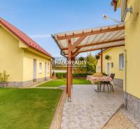 Ein Garten bei einem Einfamilienhaus in Beša mit einer Terrasse und gepflegtem Rasen.