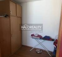 Garderobe in einer Einzimmerwohnung mit Holzdekor, Aufbewahrungsschränke, Bügelbrett.