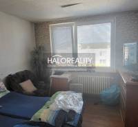 Ein Zimmer in einer Einzimmerwohnung mit einem Bett, einem Sessel, einem Fernseher und einem großen Fenster.