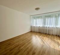 Helles Zimmer mit Vorhängen und Holzboden in einer 3-Zimmer-Wohnung.