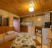 Innenraum mit Tisch, Stühlen und einem Sessel mit Stoffbezug, Boden mit Holzdekor.