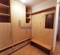 Eingangsbereich in einer 2-Zimmer-Wohnung mit Holzmöbeln und Spiegel.