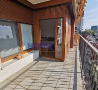 Balkon mit Fliesen, Holzfenstern und Blick auf die Umgebung in einer 2-Zimmer-Wohnung.