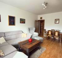 Wohnzimmer in einer 3-Zimmer-Wohnung mit Ecksofa und Boden in Holzoptik.