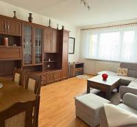 Wohnzimmer in einer 3-Zimmer-Wohnung mit Holzboden und großer Sitzgarnitur.