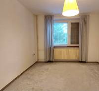 Ein geräumiges Zimmer mit Vorhängen und Teppich in einer 3-Zimmer-Wohnung.
