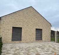 Ein Einfamilienhaus in der Fialkova-Straße in Tomášov mit einer Ziegelfassade und einem gepflasterten Hof.