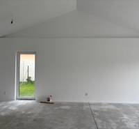 Weiße Wand und Betonboden im Einfamilienhaus, bereit zur Fertigstellung des Innenraums.