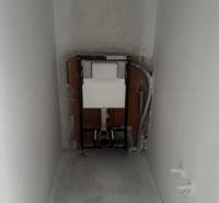 Installation für ein hängendes WC im Badezimmer eines Einfamilienhauses. Die Wände und der Boden sind roh.