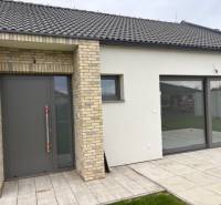 Einfamilienhaus in der Fialkova in Tomášov mit Ziegelverkleidung und geräumigen Glastüren.