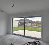 Ein Einfamilienhaus mit einer Glaswand und Blick auf den Garten.