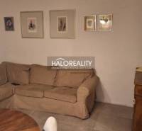 Wohnzimmer in einer 3-Zimmer-Wohnung mit Sofa, Holzboden und dekorativen Bildern.