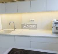 Eine Küche mit weißen Schränken und einer Kaffeemaschine in einer 3-Zimmer-Wohnung.