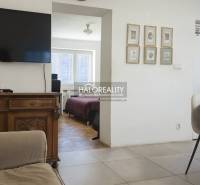 Wohnzimmer mit Fernseher, Stühlen und Blick auf das Schlafzimmer in einer 3-Zimmer-Wohnung.