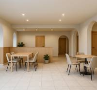 Sanft beleuchtete Geschäftsräume mit Bögen, Möbeln und Fliesen, die eine angenehme Atmosphäre schaffen.