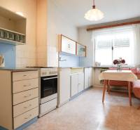 Eine Küche in einem Einfamilienhaus mit klassischer Ausstattung, einer Eckbank und einem Fenster.