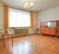 Wohnzimmer in einem Einfamilienhaus mit Möbeln und Boden in Holzoptik.