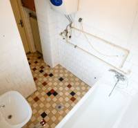 Badezimmer mit Fliesen und Badewanne in einem Einfamilienhaus.