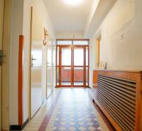 Flur in einem Einfamilienhaus mit Fliesenboden und einem hölzernen Heizkörperverkleidung.