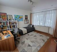 Arbeitszimmer in einer 4-Zimmer-Wohnung mit Holzboden, Bücherregal und Schreibtisch.