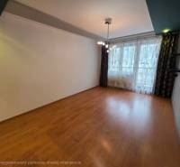 Wohnzimmer einer 4-Zimmer-Wohnung mit Holzboden und großem Fenster.