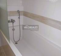 Badewanne im Badezimmer einer 2-Zimmer-Wohnung mit Keramikfliesen und Duschkopf.