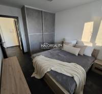 Schlafzimmer in einer 2-Zimmer-Wohnung mit dunklem Boden, großem Schrank und einfacher Einrichtung.