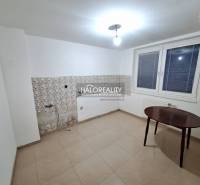 Ein Zimmer in einem Einfamilienhaus mit weißen Wänden, einem Fenster und Fliesen.