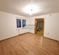 Ein Zimmer in einem Einfamilienhaus mit einem Boden in Holzoptik und weißen Wänden.