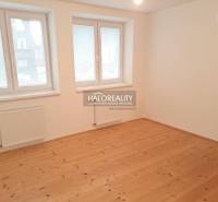 Ein Zimmer in einem Einfamilienhaus mit einem Boden in Holzoptik und weißen Wänden.