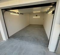 Garage in der Sonnenstraße in Komárno mit Betonboden und einem aufklappbaren Tor.