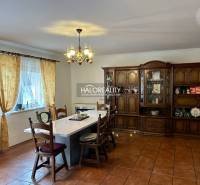 Ein geräumiges Esszimmer in einem Einfamilienhaus mit einem großen Tisch und einer hölzernen Wohnwand.