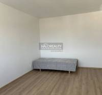 Einfaches Zimmer in einer Einzimmerwohnung mit Bett und Holzboden.