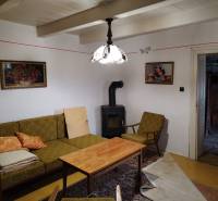 Wohnzimmer eines Einfamilienhauses mit Kachelofen, antiken Möbeln und Dekorationen.